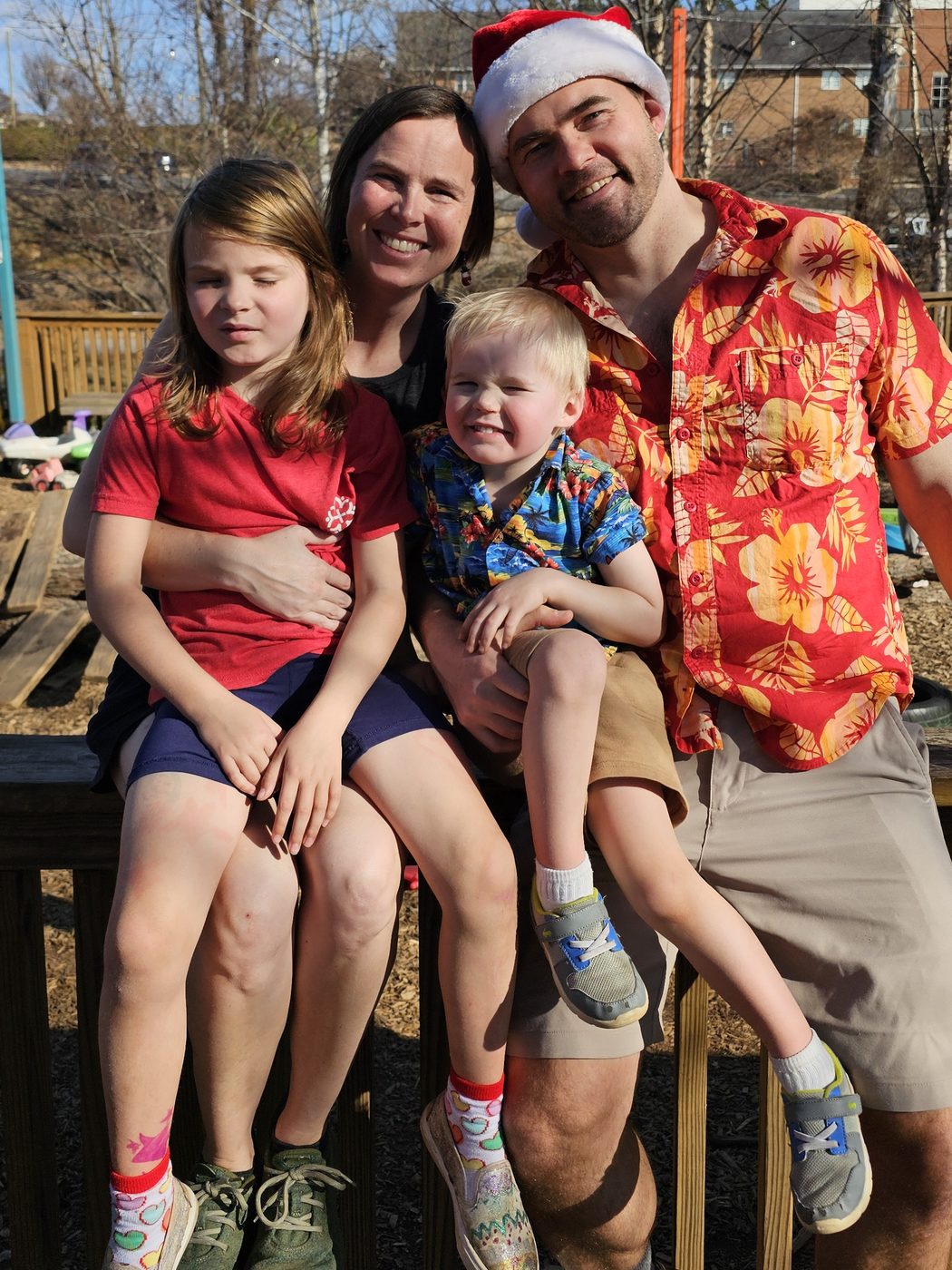 Cody, Kabe, and their two kids outdoors at Christmas